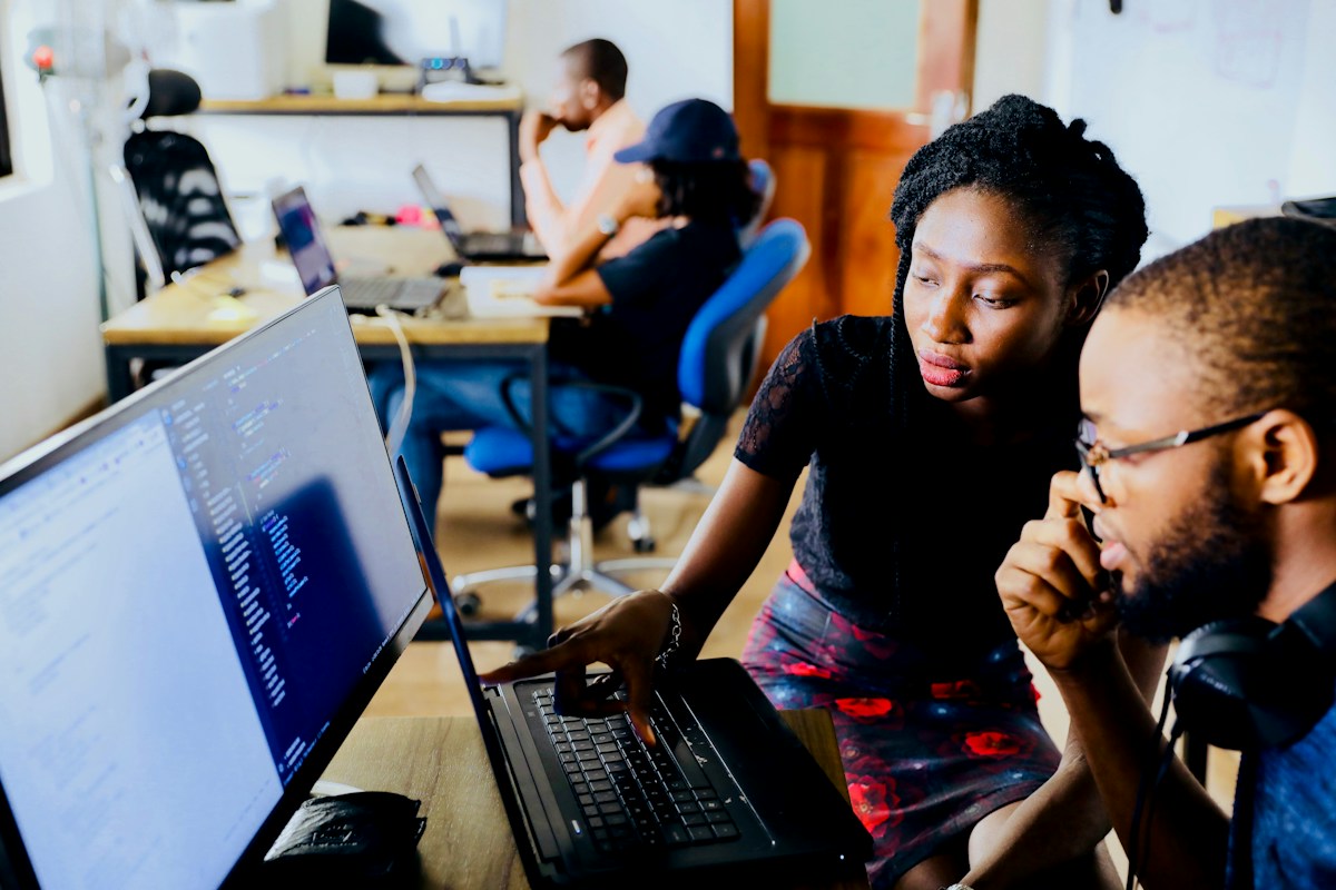 Two colleagues solving a problem at a monitor